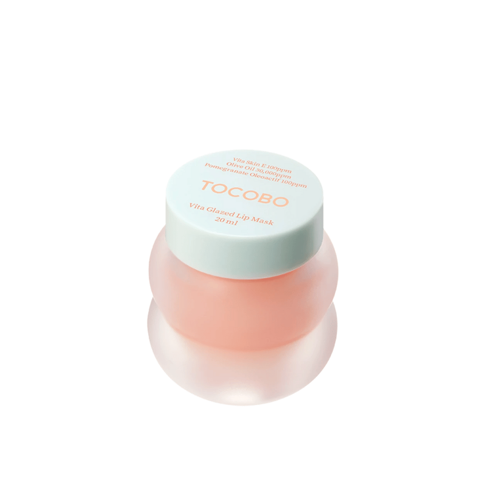 Pojemnik z "Vita Glazed Lip Mask" od Tocobo jest pokazany. Pojemnik jest okrągły i przezroczysty z jasnoturkusową pokrywką. Maska wewnątrz jest delikatnie różowa i zaprojektowana do nawilżania i pielęgnacji ust. Produkt ma objętość 20 ml.