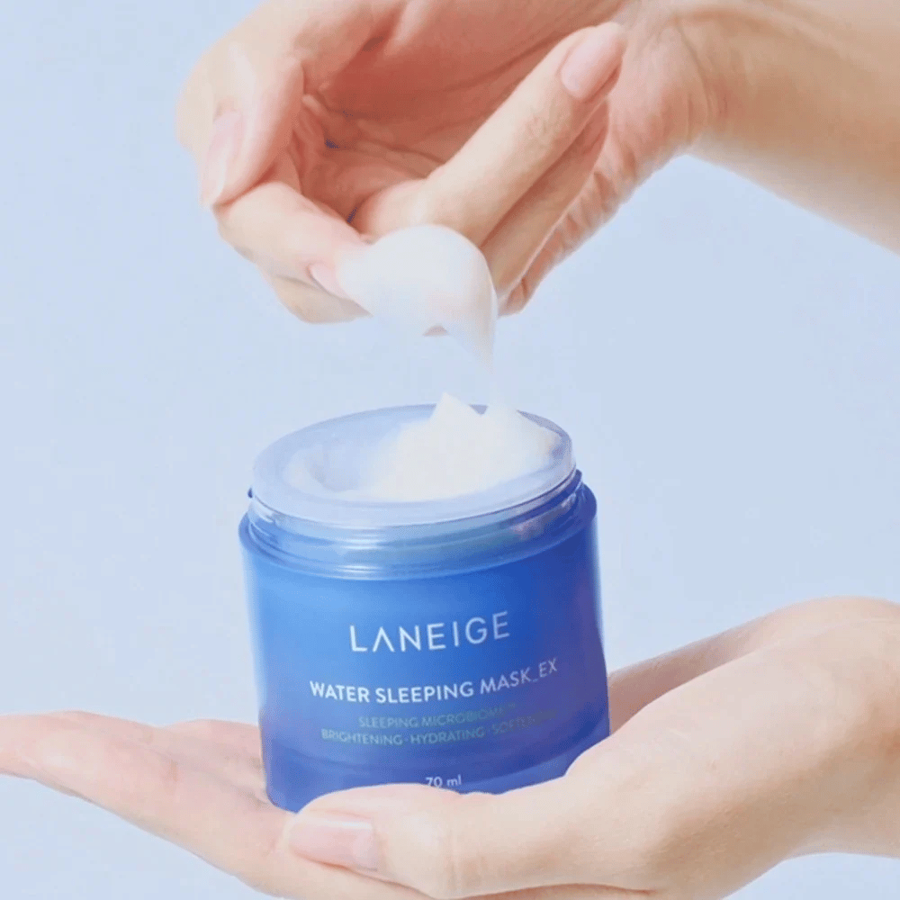Ręka nabiera LANEIGE Water Sleeping Mask z niebieskiego słoika, z naciskiem na żelową konsystencję na jasnoniebieskim tle.