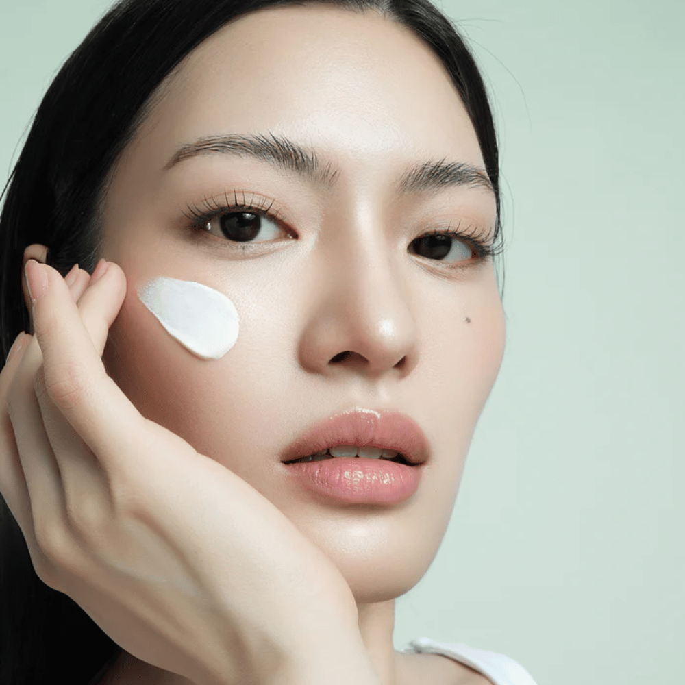 Modelka nakłada d’Alba Waterfull Mild Sun Cream SPF 50+ na twarz. Lekka, nawilżająca ochrona przeciwsłoneczna z filtrem mineralnym, idealna do codziennego użytku i dla wrażliwej skóry.