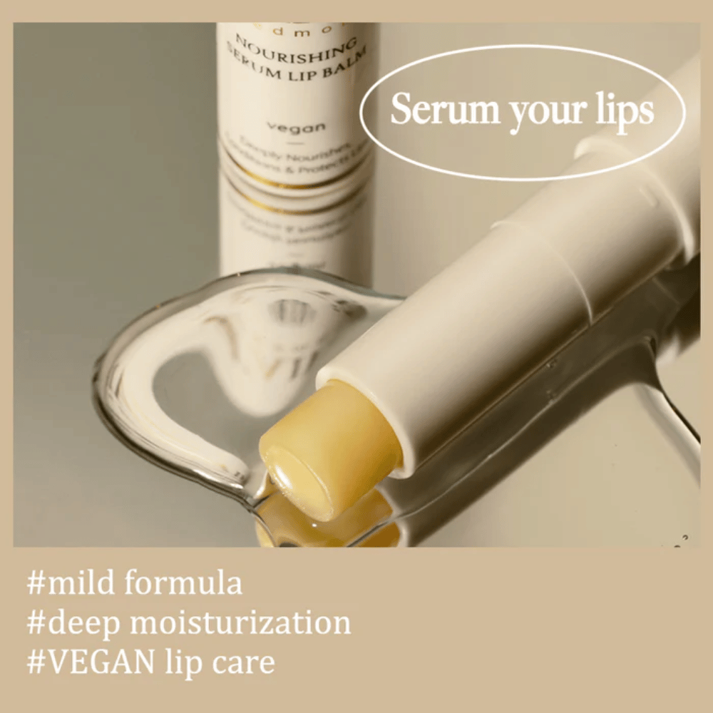d'Alba Nourishing Serum Lip Balm w zbliżeniu leżący na lustrze z informacją o łagodnej formule, głębokim nawilżeniu i wegańskiej pielęgnacji ust.