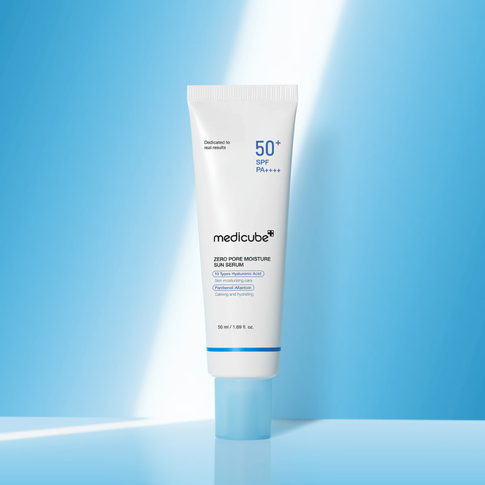 Medicube Zero Pore Moisture Sun Serum SPF50+ PA++++ przedstawione na niebieskim tle. Nawilżające serum przeciwsłoneczne z kwasem hialuronowym, pantenolem i alantoiną do codziennej ochrony UV i pielęgnacji skóry.