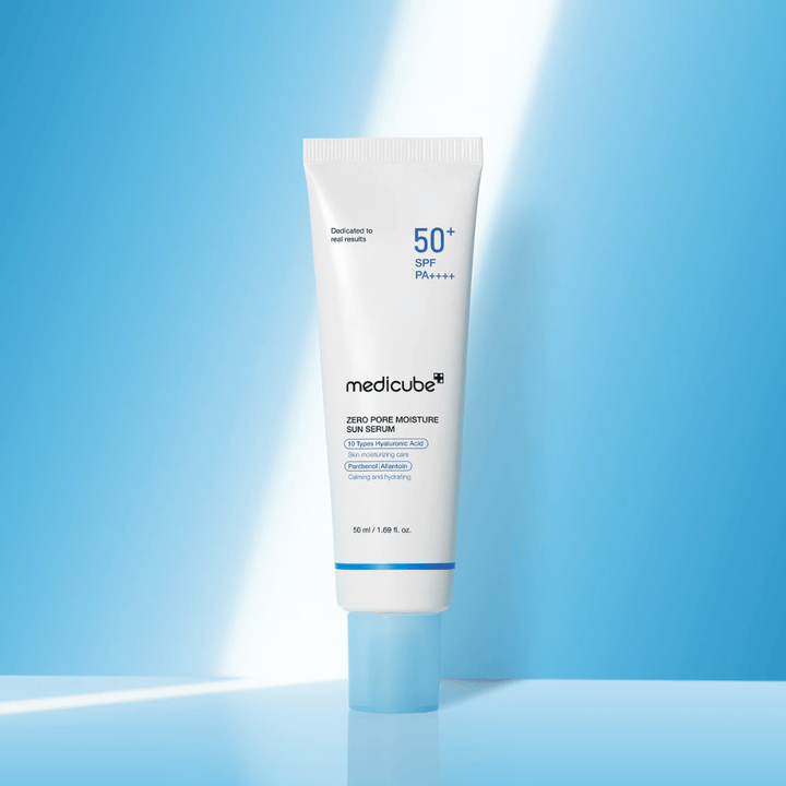 Medicube Zero Pore Moisture Sun Serum SPF50+ PA++++ przedstawione na niebieskim tle. Nawilżające serum przeciwsłoneczne z kwasem hialuronowym, pantenolem i alantoiną do codziennej ochrony UV i pielęgnacji skóry.