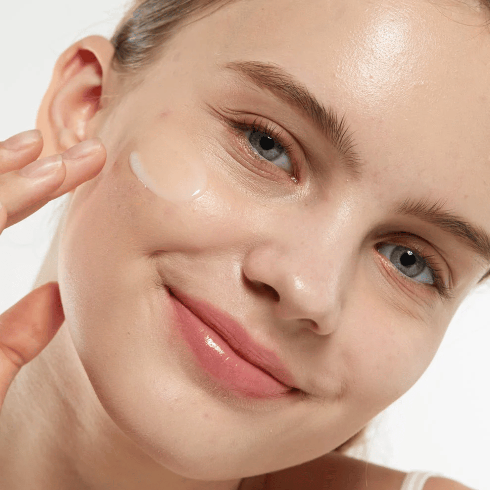 Modelka aplikująca Medicube Zero Pore Serum 2.0 na policzek, serum poprawiające strukturę skóry, nawilżające i nadające naturalny blask.