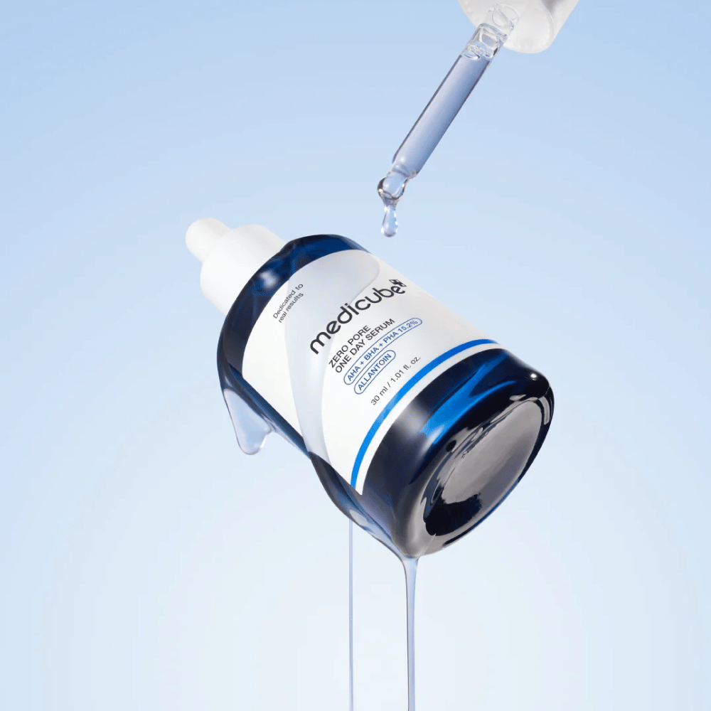 Flaska av Medicube Zero Pore One Day Serum med pipett och rinnande serumdroppar mot en ljusblå bakgrund.