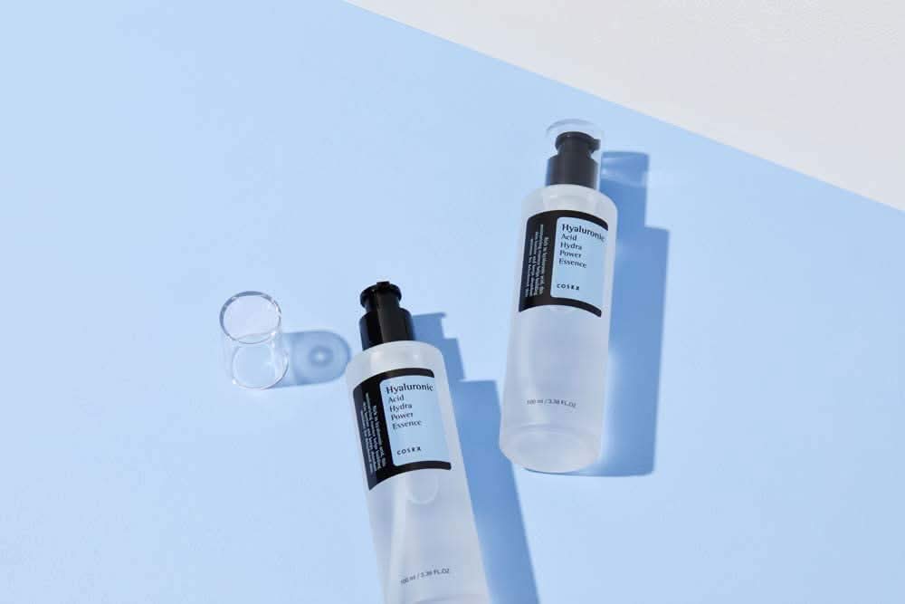COSRX:s Hyaluronic Acid Hydra Power Essence 100ml zapewnia nawilżające korzyści na niebieskiej powierzchni.