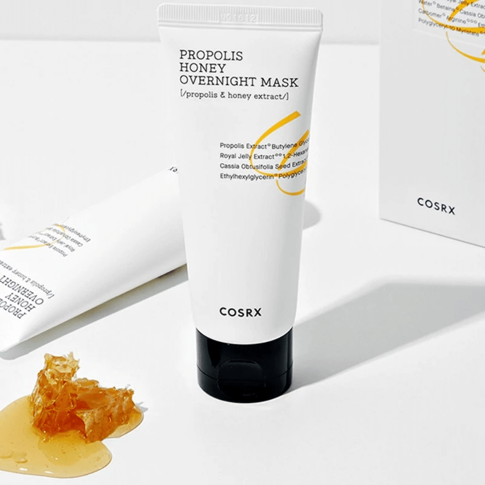 Pudełko Full Fit Propolis Honey Overnight Mask 60ml z COSRX z butelką miodu obok, z ekstraktem z propolisu.