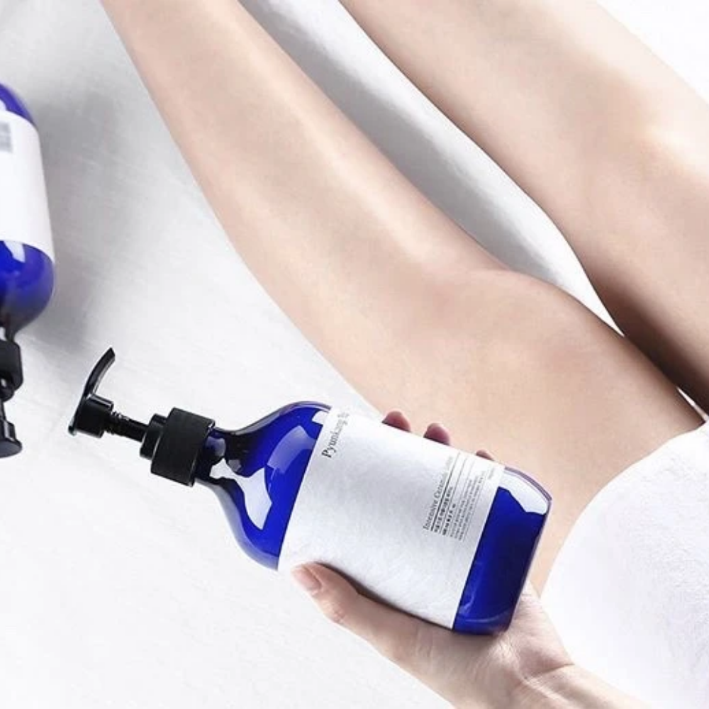 Kobieta trzymająca butelkę Pyunkang Yul Intensive Ceramide Lotion 500ml obok swoich nóg.
