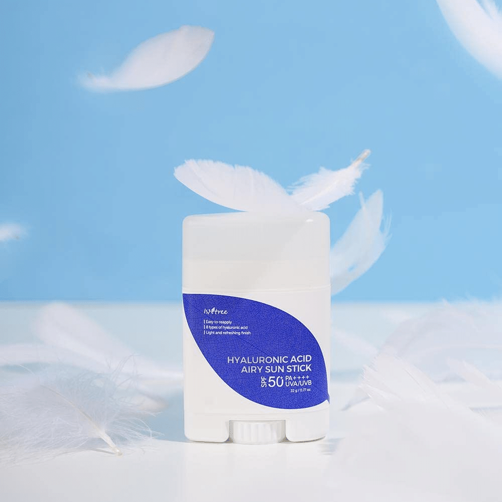 Krem Isntree Hyaluronic Acid Airy Sun Stick z SPF 50+ i kwasem hialuronowym, ozdobiony białymi piórami.