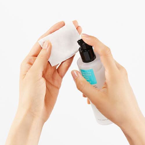 Ręka pokazująca użycie COSRX Two In One Poreless Power Liquid 100ml dla skóry tłustej.